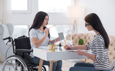 Accurate prediction. Intelligent disabled woman and colleague working together while using pencils