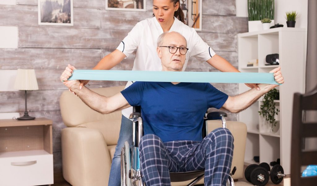 old-man-doing-muscle-injury-exercise-using-resistance-band-with-nurse-beside_482257-109