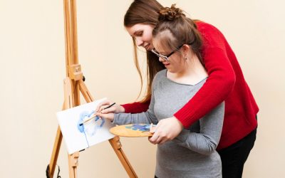 side-view-woman-helping-girl-with-down-syndrome-paint_23-2148464607